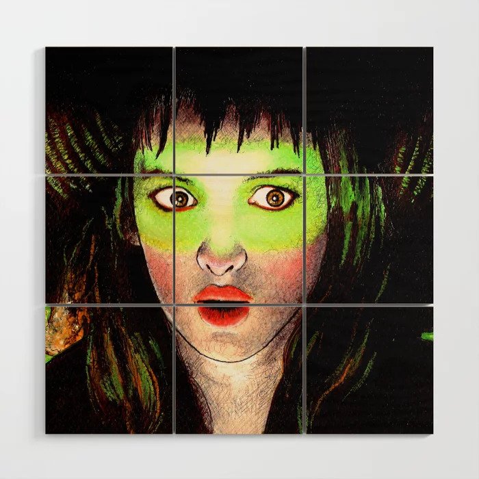 Photo of wall art featuring drawing of Lydia Deetz looking shocked with green light shining in her eyes