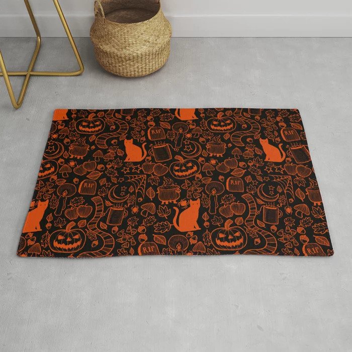 Picture of a floor rug with Halloween decor elements like cats, pumpkins, moons and tombstones. The rug is black and the pattern is orange.